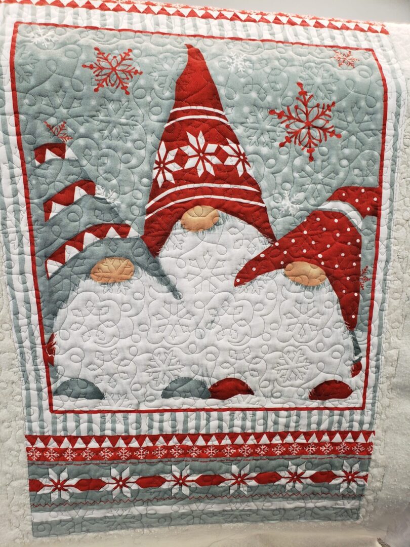 A quilt with three gnomes on it