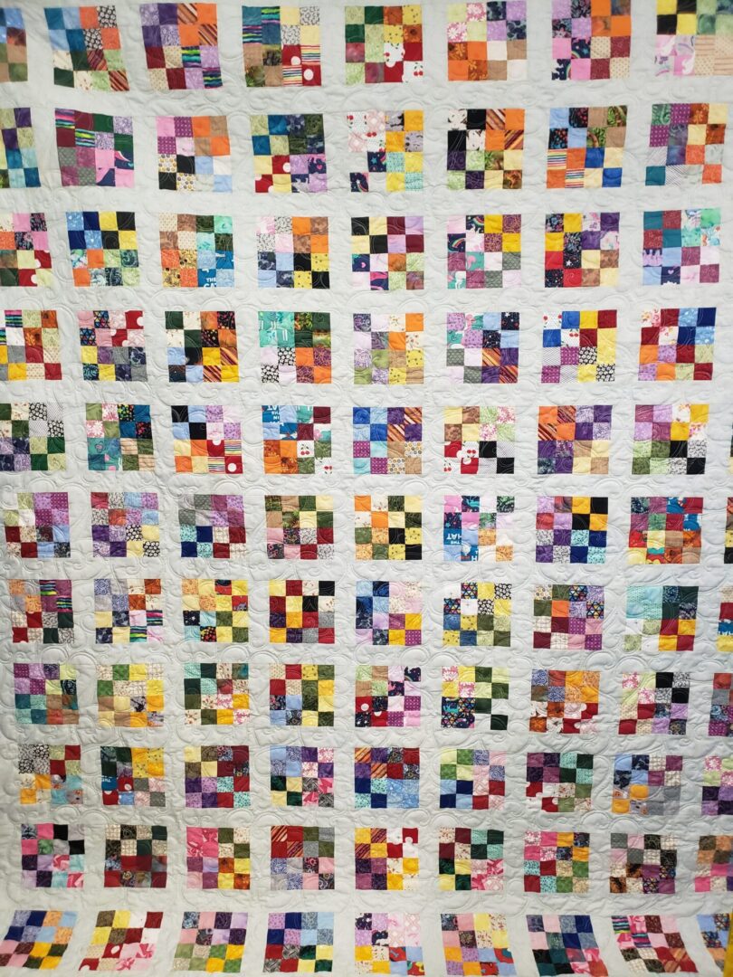 A quilt with many different colors of squares.