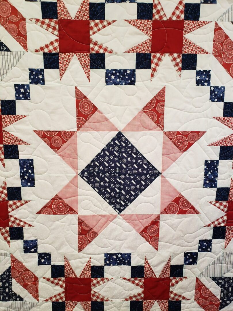 A quilt with red, white and blue designs.