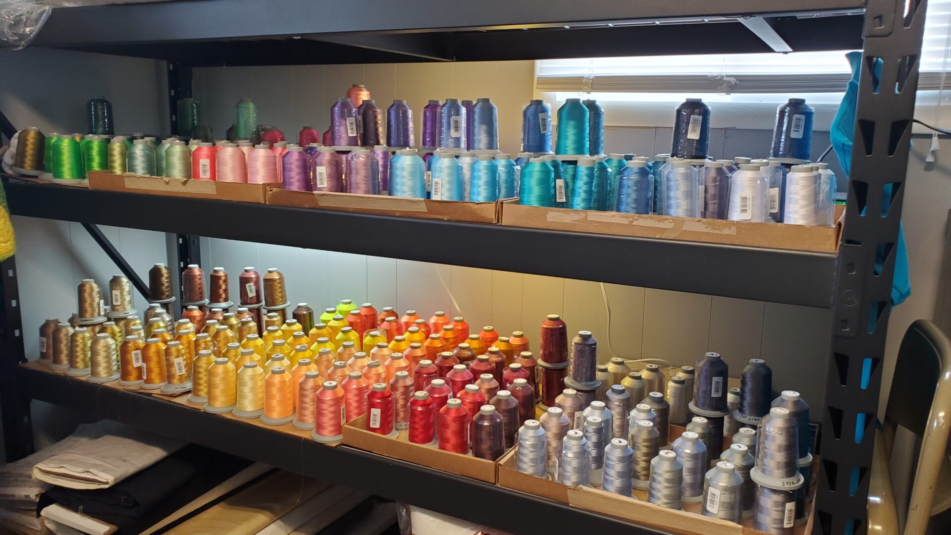 A shelf filled with many different colors of thread.